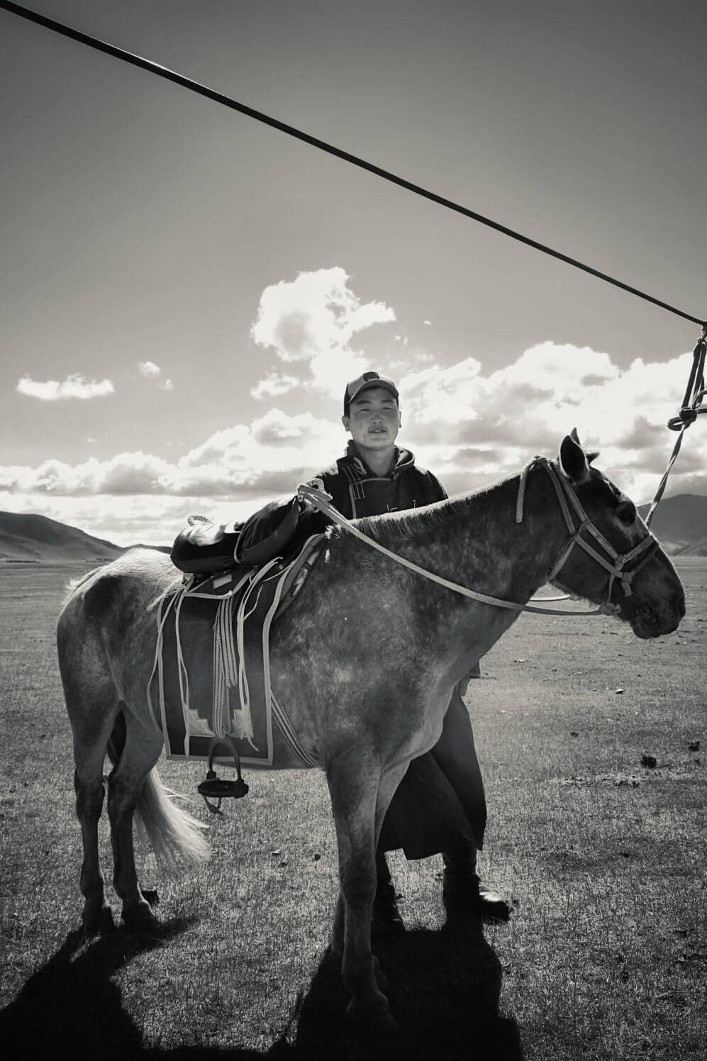 Suma standing with his horse on the open steppe