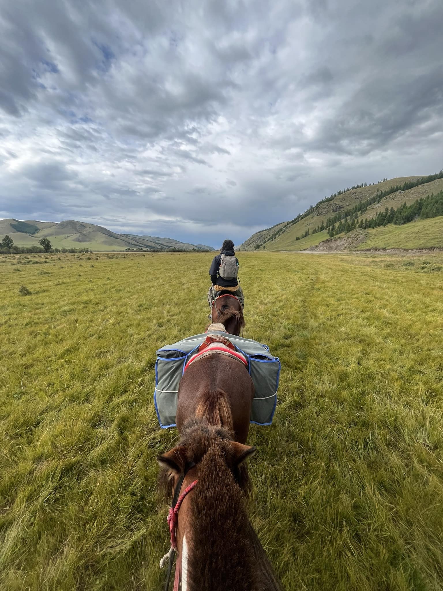 Rider under dramatic storm clouds in the valley