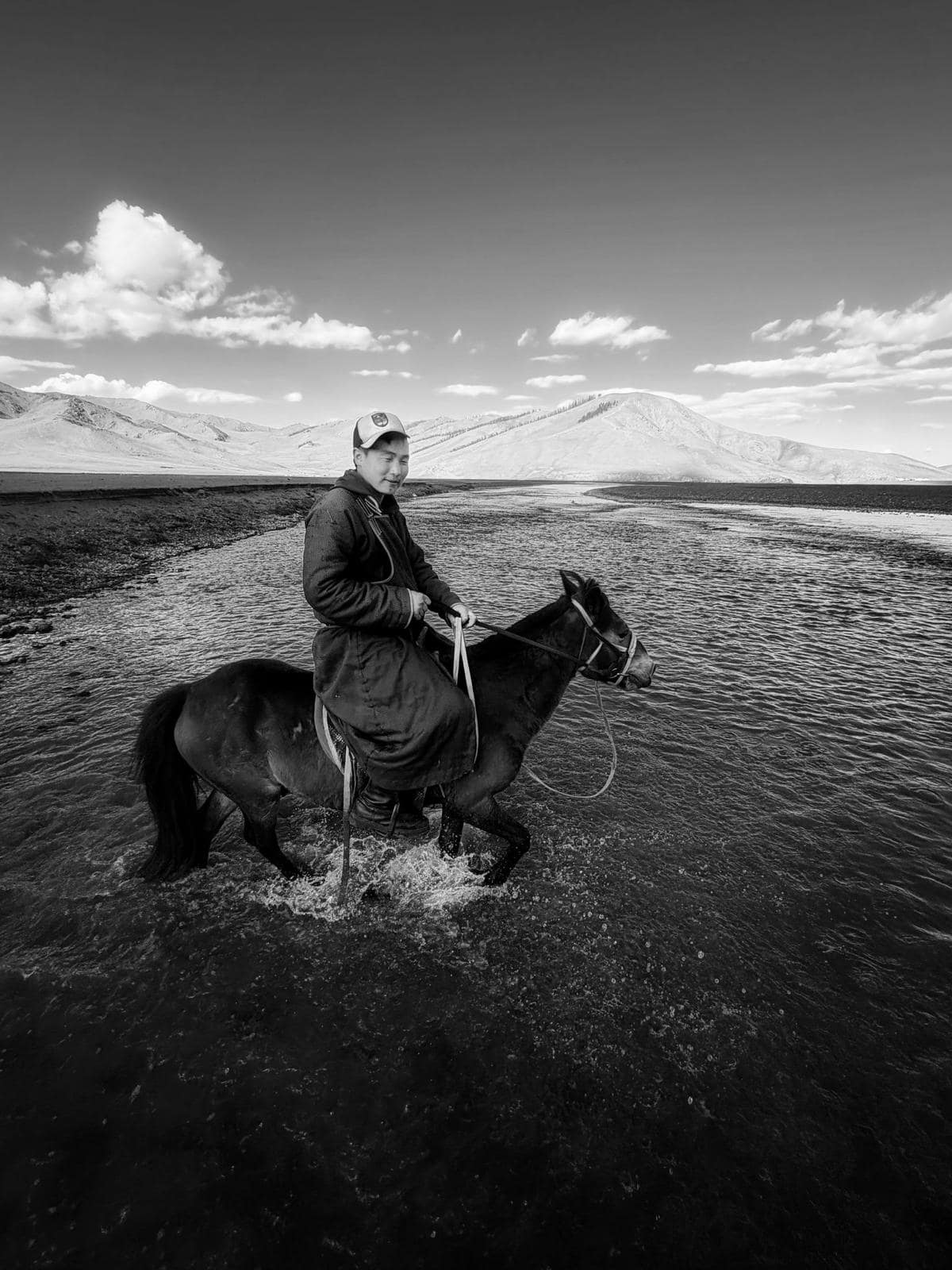 Suma riding through a shallow river crossing