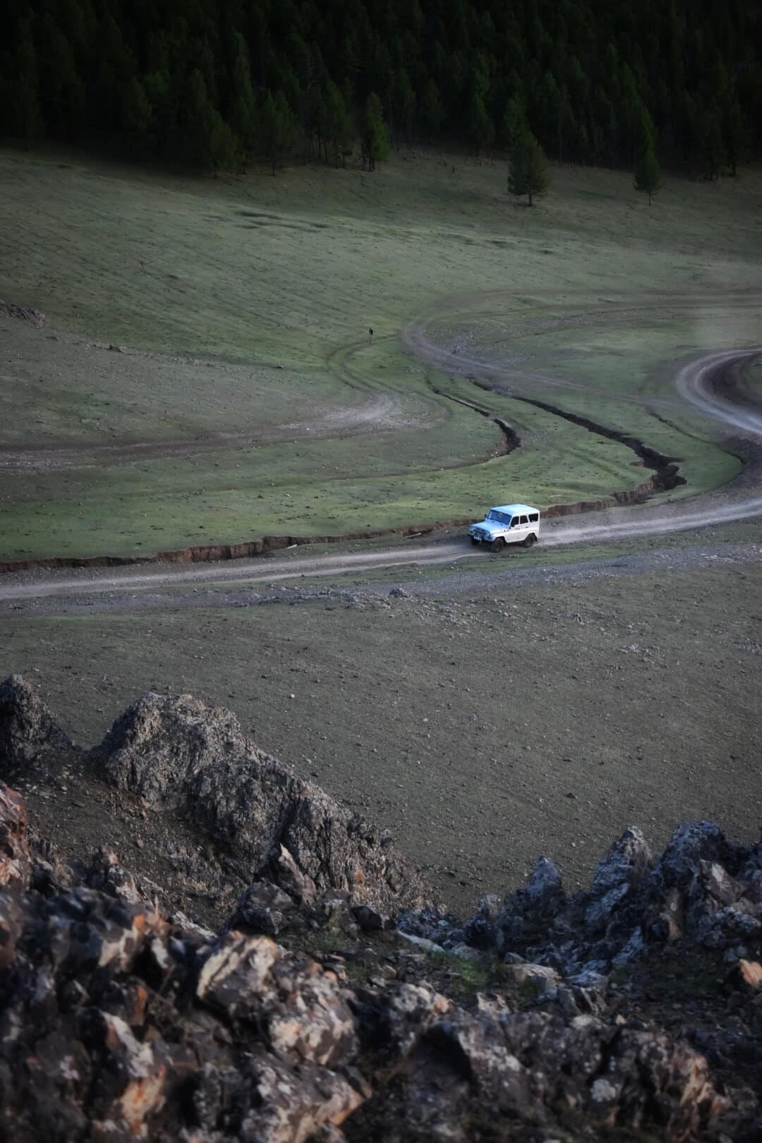 White van crossing a remote valley road
