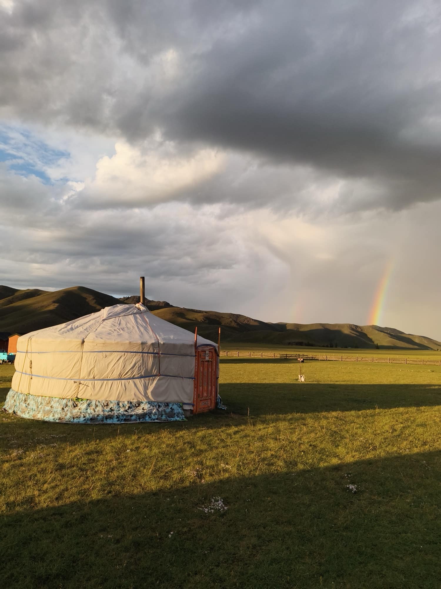 A ger on the steppe with a rainbow after rain