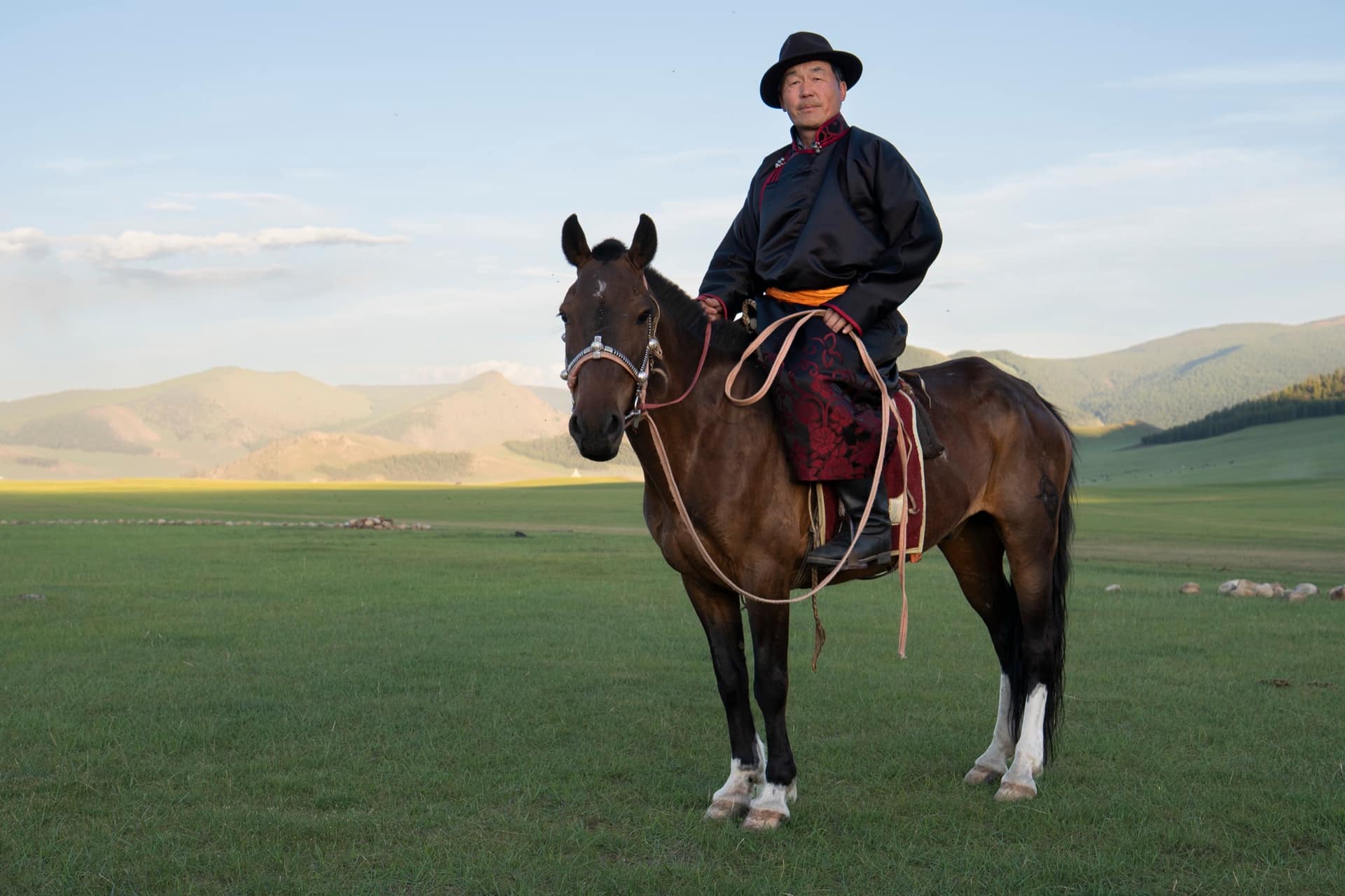 Host in a black deel mounted on his horse as the light drops