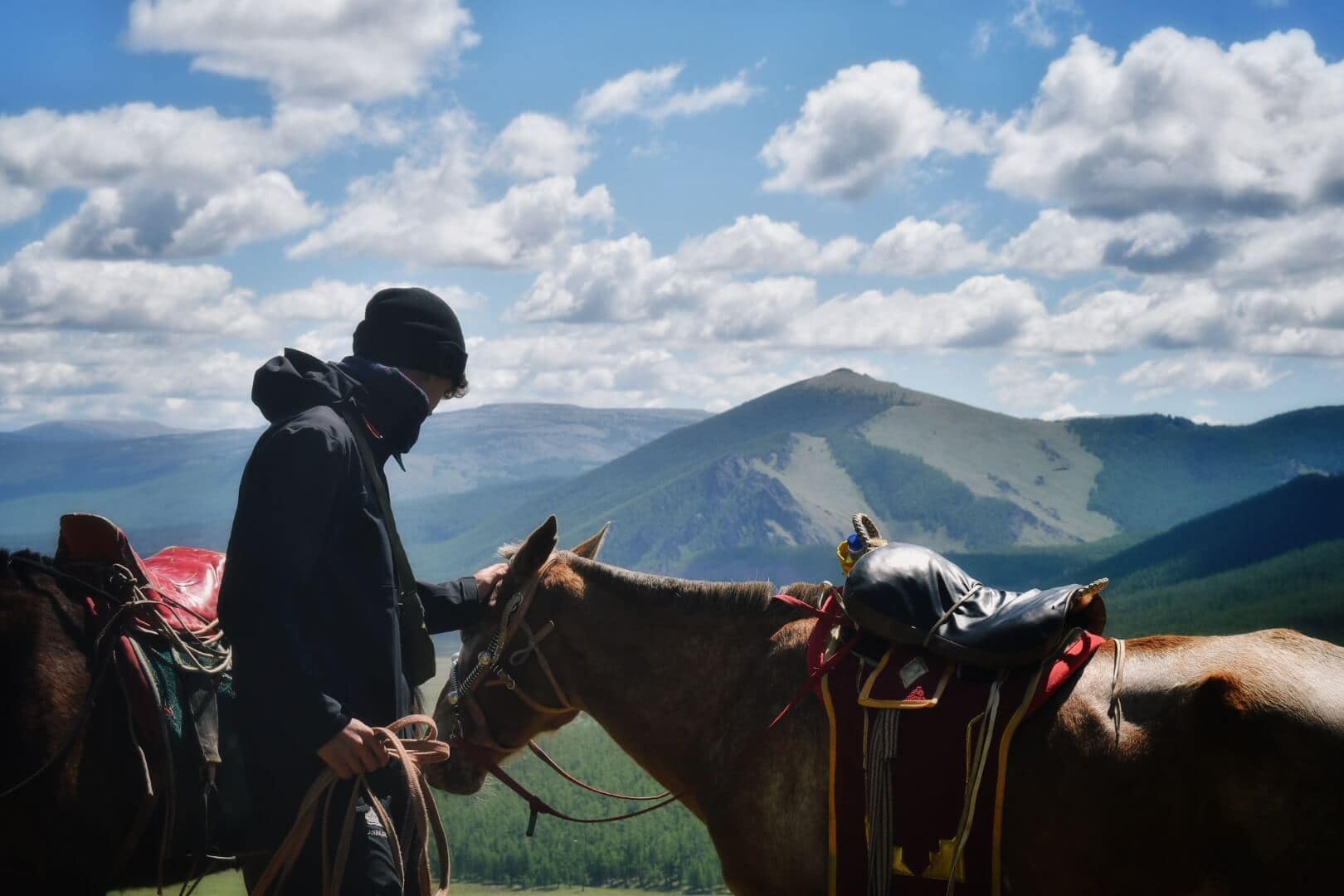 Rider and horse below mountain clouds