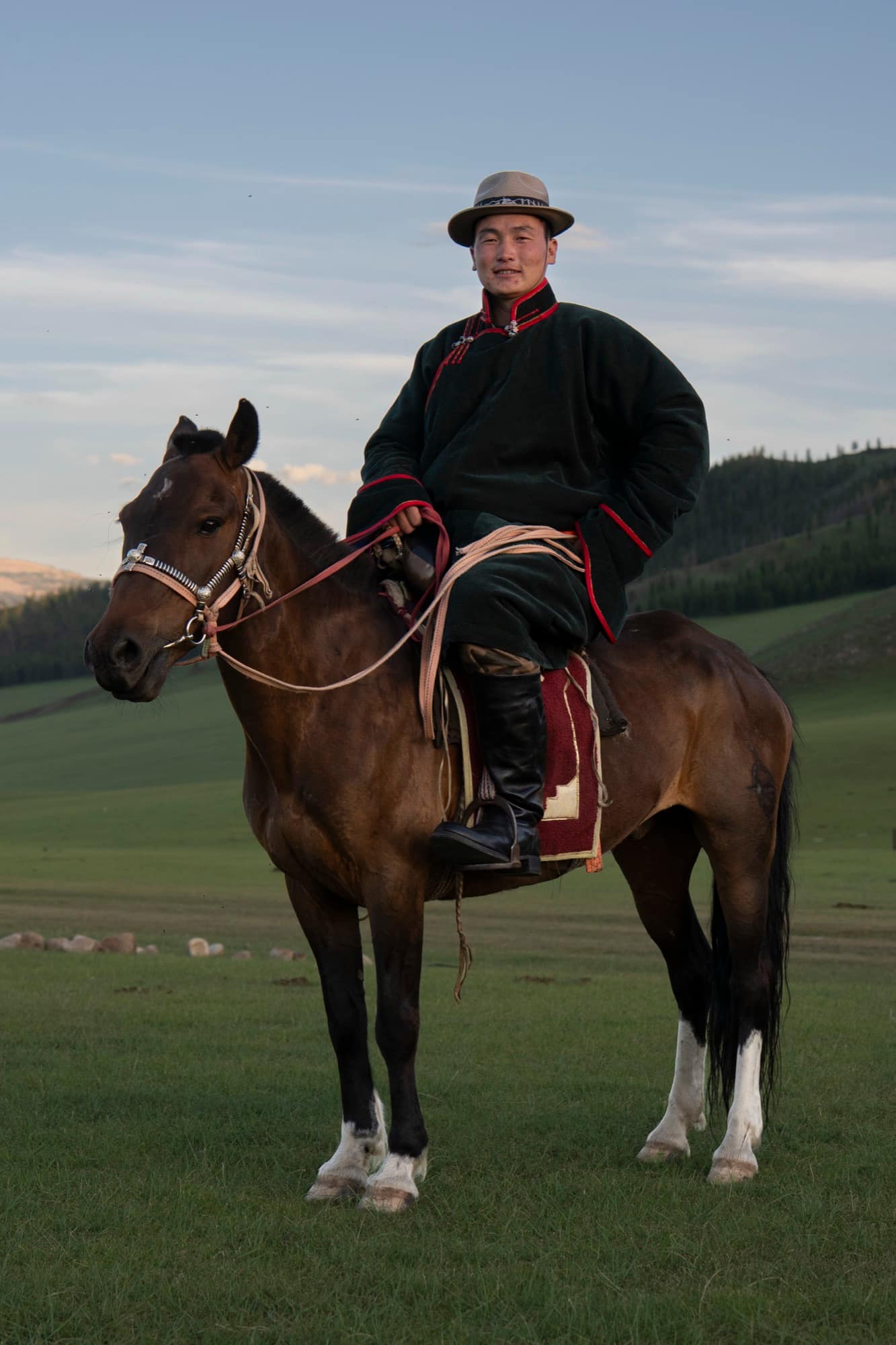 Young horseman in a green deel astride his horse at dusk