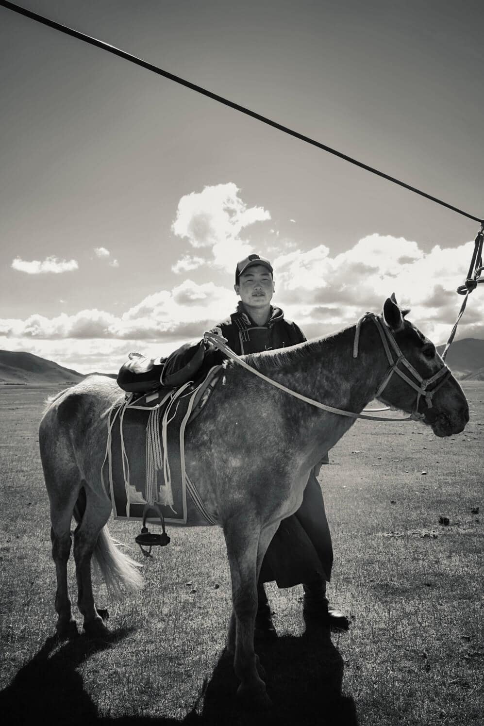 Suma standing with his horse on the open steppe