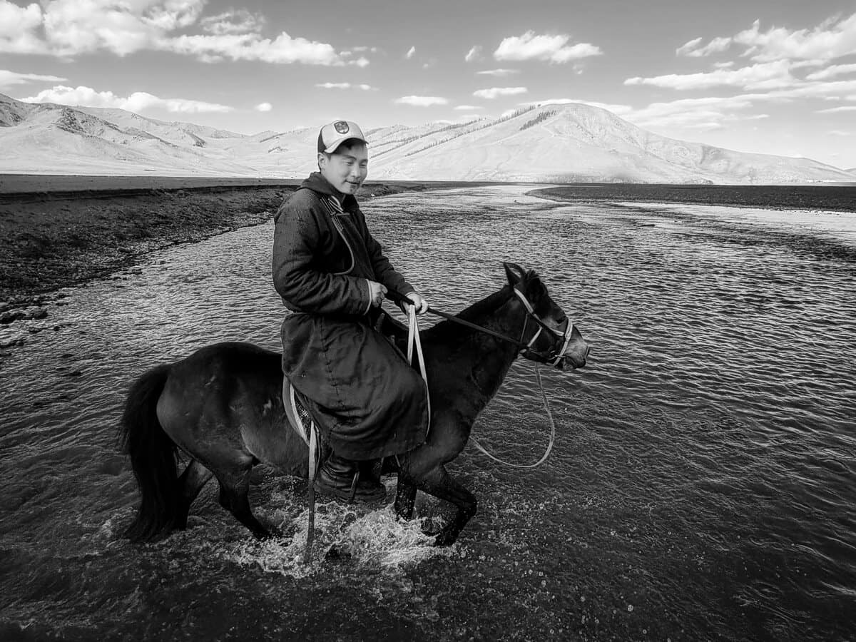 Rider crossing shallow water on horseback